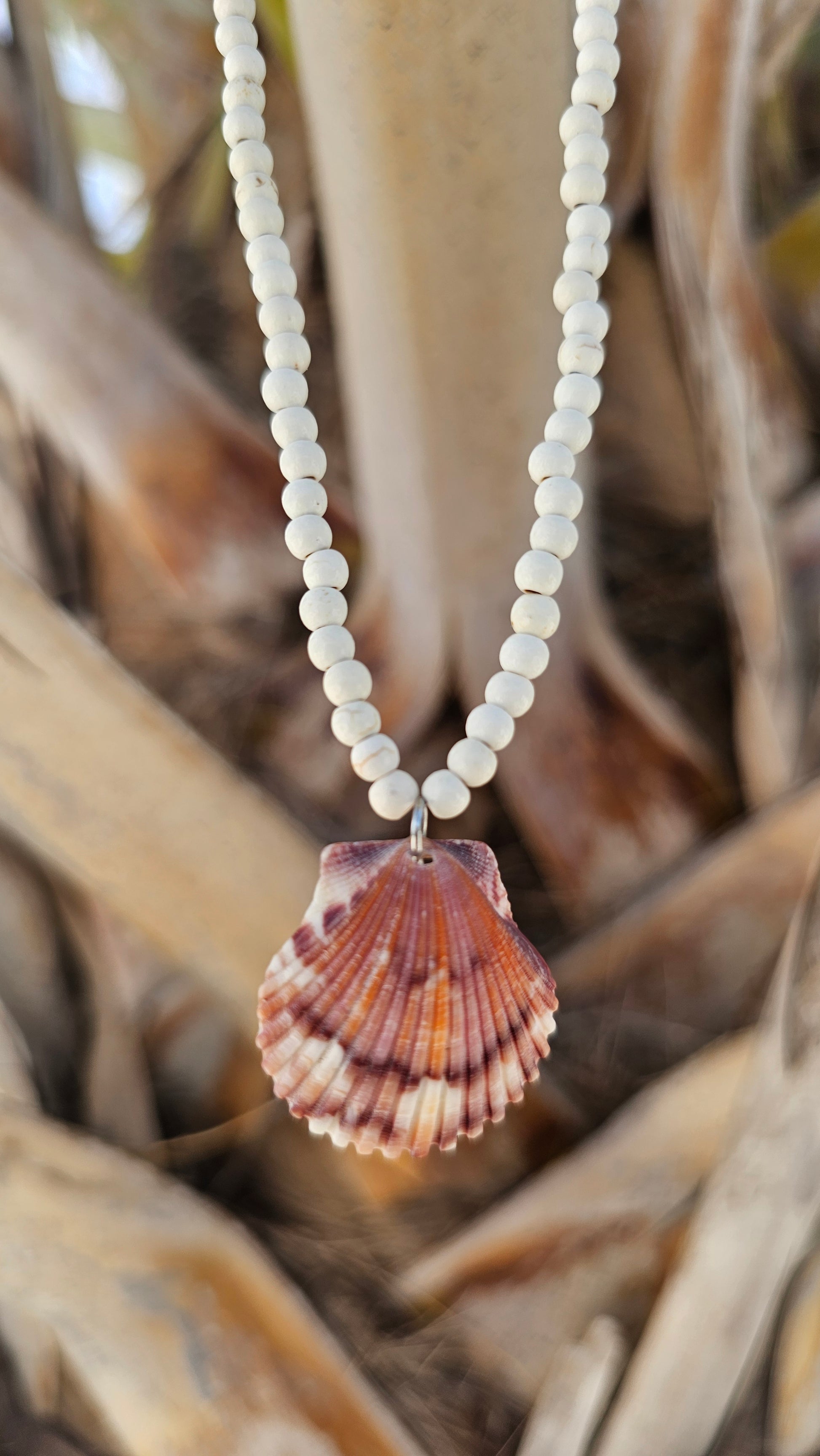 purple and orange scallop shell pendant on a white magnesite beaded necklace